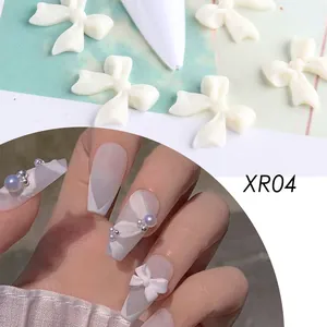 Dettaglio di fiocchi 3D per nail art in resina bianca opaca con perle viola iridate