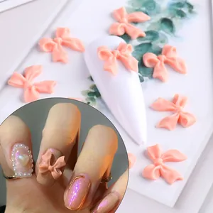 Vista macro di fiocchi 3D rosa opaco per nail art con texture morbida e dettagli curati