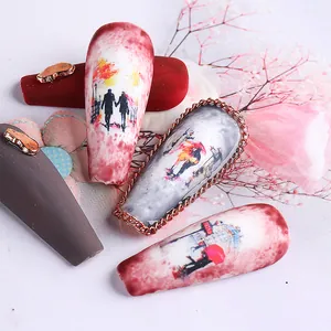 Detailed macro view of long almond nail art with artistic illustrations and gold accents