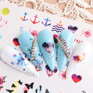 Detailed view of summer nail stickers with palm trees and rhinestones on blue and white tips