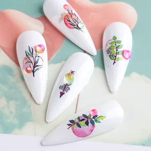 Macro detail of almond nail tips featuring botanical patterns and colorful rhinestones