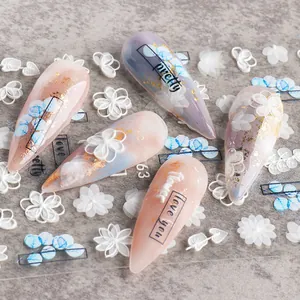 Macro shot of 5D white floral embossed nail stickers with gold foil and English text