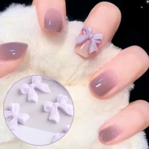 Charm per unghie a fiocco 3D in resina opaca lilla su manicure sfumata viola e sfondo soffice
