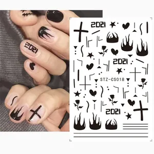 Close-up of black gothic nail stickers featuring crosses, flames, and roses on a hand