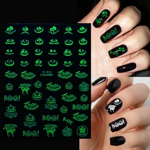 Luminous Halloween nail stickers with pumpkins and ghosts showing glowing effect in the dark