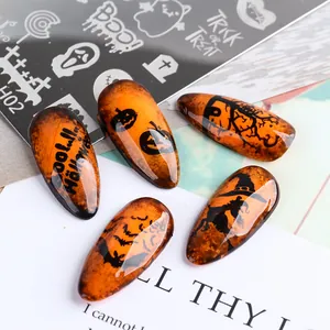Makroaufnahme von Halloween-Nagelplatten mit Kürbis-, Hexen- und Fledermausmotiven auf Nägeln