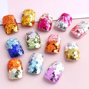 Macro di undici glitter esagonali colorati per unghie con finitura metallica cangiante