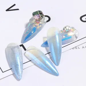 Macro view of icy blue stiletto fake nails with cat eye finish and 3D diamond accents