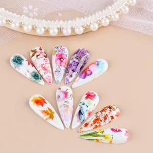 Detail view of stiletto nails with autumn maple leaves and lavender floral patterns