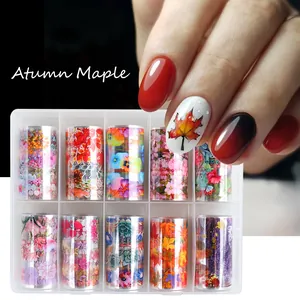 Macro view of 10-roll autumn maple leaf and floral nail foil set in a clear box