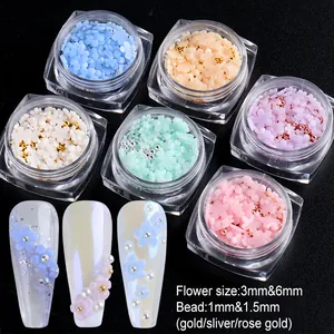 Macro detail of 3D resin flower nail charms and steel beads in transparent square bottles