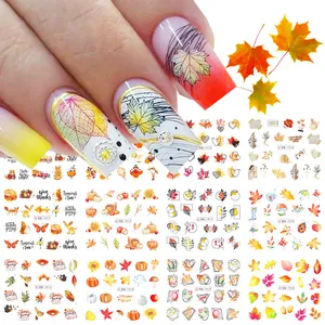 Macro detail of Autumn maple leaf and pumpkin nail art stickers for Thanksgiving manicure