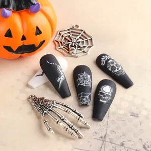 Dettaglio di unghie finte Halloween nero opaco con ragnatele bianche e motivi di teschi