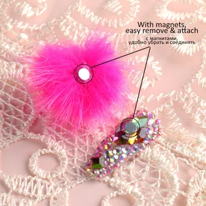 Pompom magnetico rosa per unghie con strass colorati su uno sfondo di pizzo fine