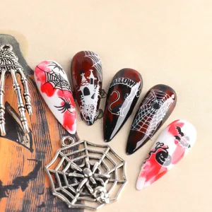 Dettaglio macro di adesivi 3D luminosi per unghie di Halloween con ragnatele e teschi