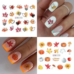 Detail of autumn maple leaf and pumpkin nail stickers with heart patterns and warm tones