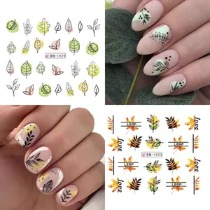 Macro detail of autumn maple leaf nail art stickers with abstract lines and leaf patterns