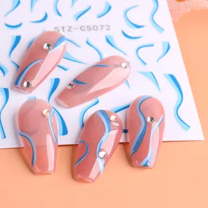 Primer plano de pegatinas de uñas con ondas azules y pequeños cristales brillantes