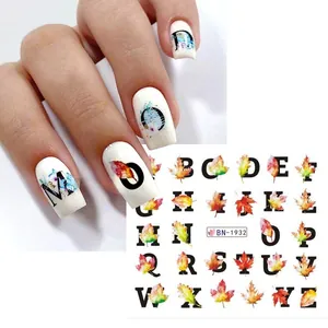 Close-up of fall nail art stickers featuring maple leaf designs and English alphabet letters