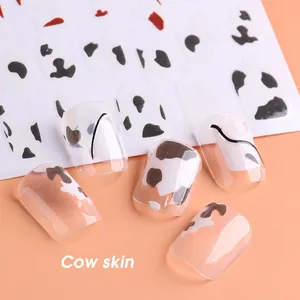 Vista detallada de las pegatinas de uñas con estampado de vaca en puntas transparentes