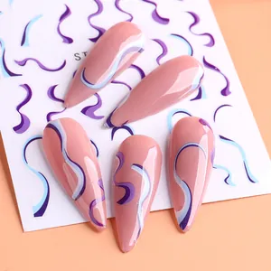Primer plano de uñas postizas largas con diseño de líneas onduladas en púrpura y azul