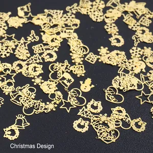 Vue macro de décorations d'ongles de Noël dorées avec flocons de neige et rennes en métal