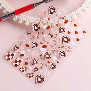 Detail of nail art stickers featuring brown checkerboard hearts and smiley faces STZ-CS078
