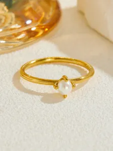 Detailed shot of a vintage pearl ring with a polished gold-plated four-prong setting