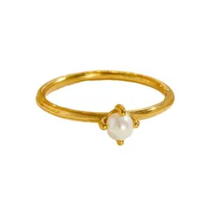 Elegant minimalist titanium steel ring with a four-prong pearl setting on golden band