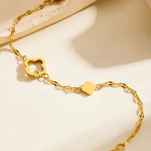Elegante pulsera de trébol en acero de titanio dorado con diseño hueco y dijes pulidos
