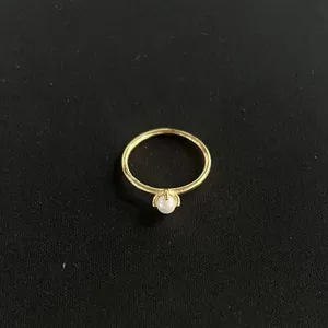 Minimalist titanium steel ring featuring a small white pearl on a gold band for women