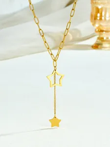 Detail of gold star pendant necklace with paperclip chain and elegant tassel design