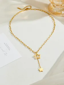 Detail of gold star pendant necklace with rectangular links and tassel star drop charm