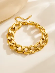Macro-opname van een gouden Cubaanse schakelarmband met karabijnsluiting op lichte achtergrond