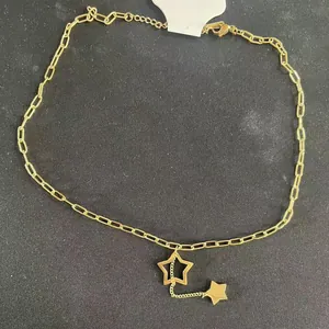 Minimalist gold star necklace with paperclip chain and hollow star pendant on black base