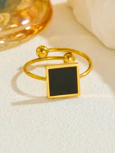 Detail of rose gold open ring featuring a black square inlay and twin metal beads
