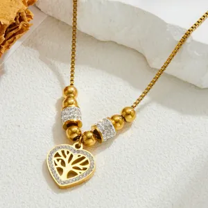 Golden heart necklace with tree of life pendant and zircon stones on white background