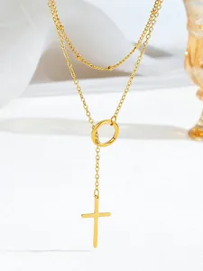 Detalle de collar de doble capa chapado en oro con colgante de cruz y bolas finas