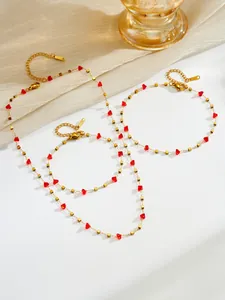 Detail van rode kristallen sieradenset met goudkleurige roestvrijstalen ketting en armband
