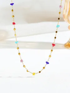Detailopname van gouden kralenketting met levendige veelkleurige kristallen hartjes