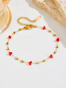 Detail van de gouden roestvrijstalen ketting met rode kristallen en karabijnsluiting