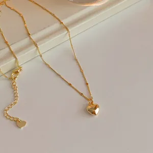 Polished gold heart pendant necklace with delicate chain and adjustable extension link