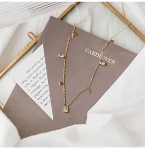 Detail of gold titanium necklace with rectangular crystal pendants and lobster clasp