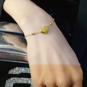 Polished gold heart pendant bracelet with beaded chain for women on wrist