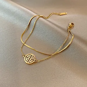 Bracciale a doppio strato dorato con catena a serpente e ciondolo rotondo su seta elegante
