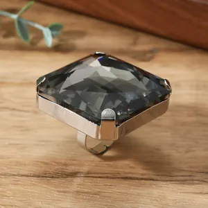 Dettaglio macro di un anello con grande cristallo quadrato e montatura argentata a quattro griffe