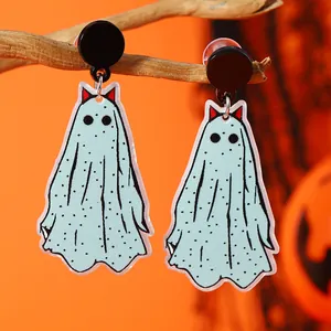 Detalle de pendientes de fantasma verde menta con lunares negros en ramas secas