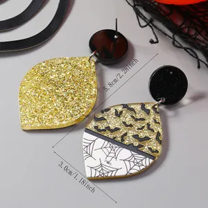 Detail van Halloween-oorbellen van acryl met gouden glitters, vleermuizen en spinnenwebben