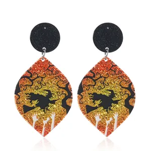 Halloween glitter acryl oorbellen met een heksensilhouet op een oranje kleurverloop