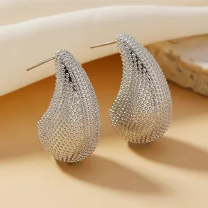 Primer plano de pendientes plateados con forma de gota y superficie de textura rugosa